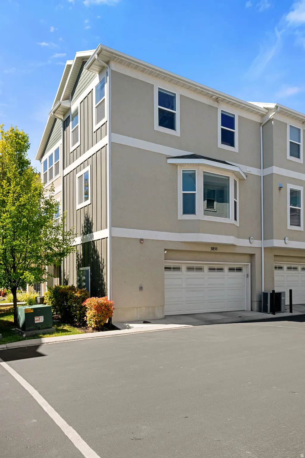 Multi-level townhome featuring a neutral stucco exterior with contrasting vertical siding