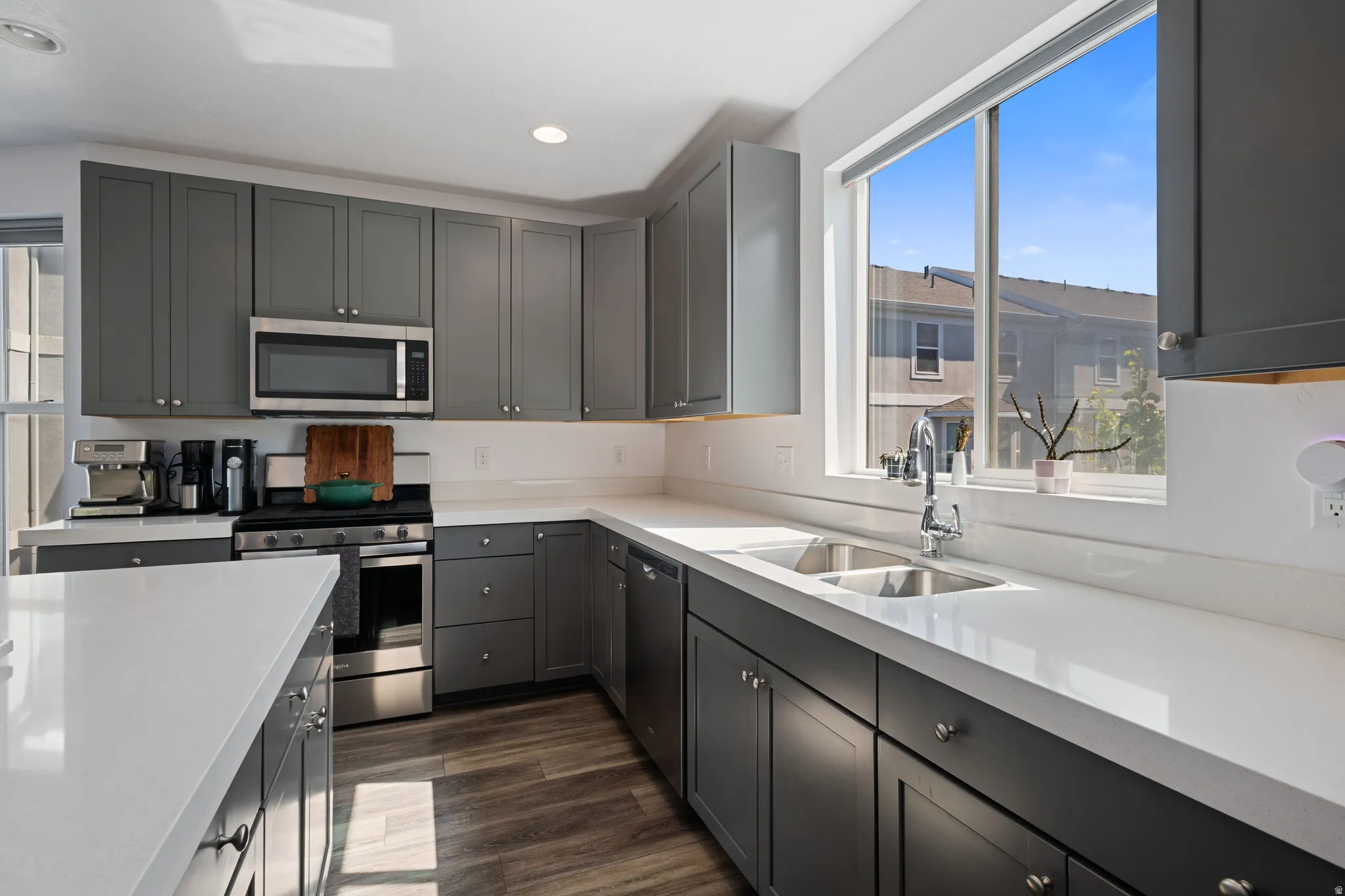 Modern kitchen featuring dark gray cabinetry and light-toned countertops