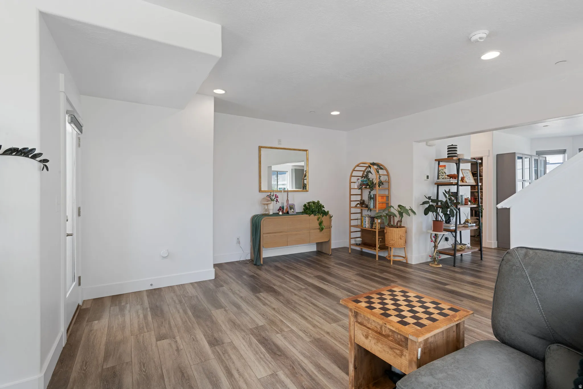 Spacious living area featuring wood-finish flooring, recessed lighting, and white baseboards