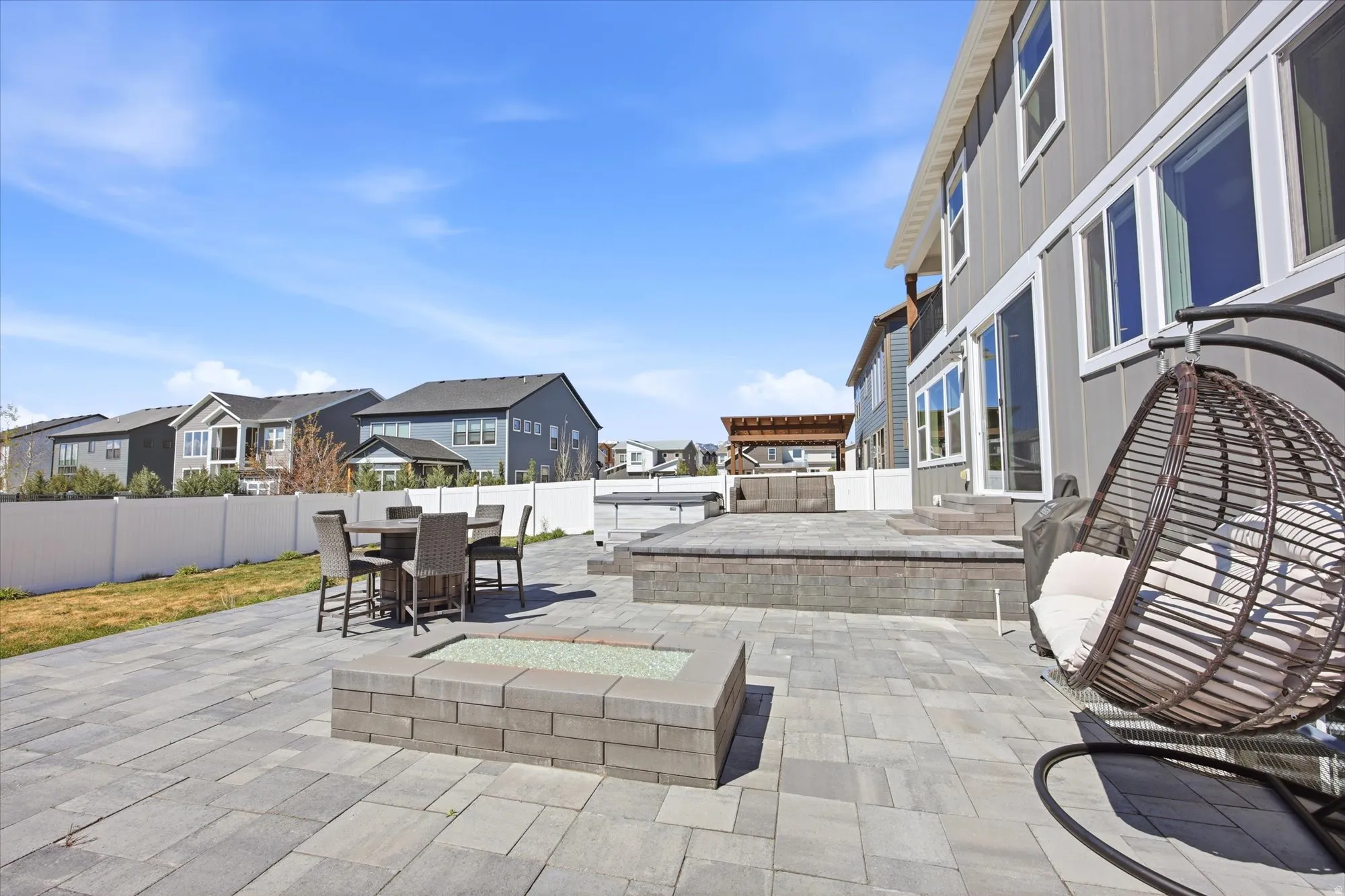 Expansive paver patio featuring a built-in fire pit