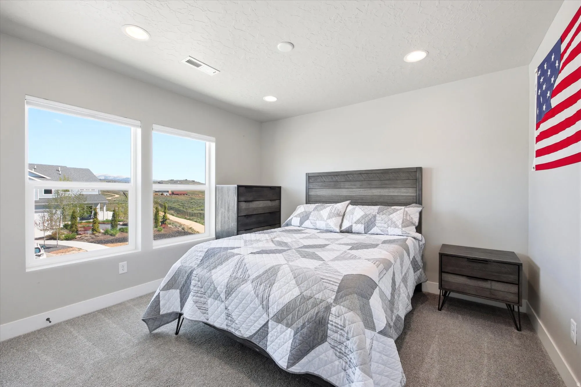 Carpeted room featuring dual windows, recessed lighting, and white baseboards