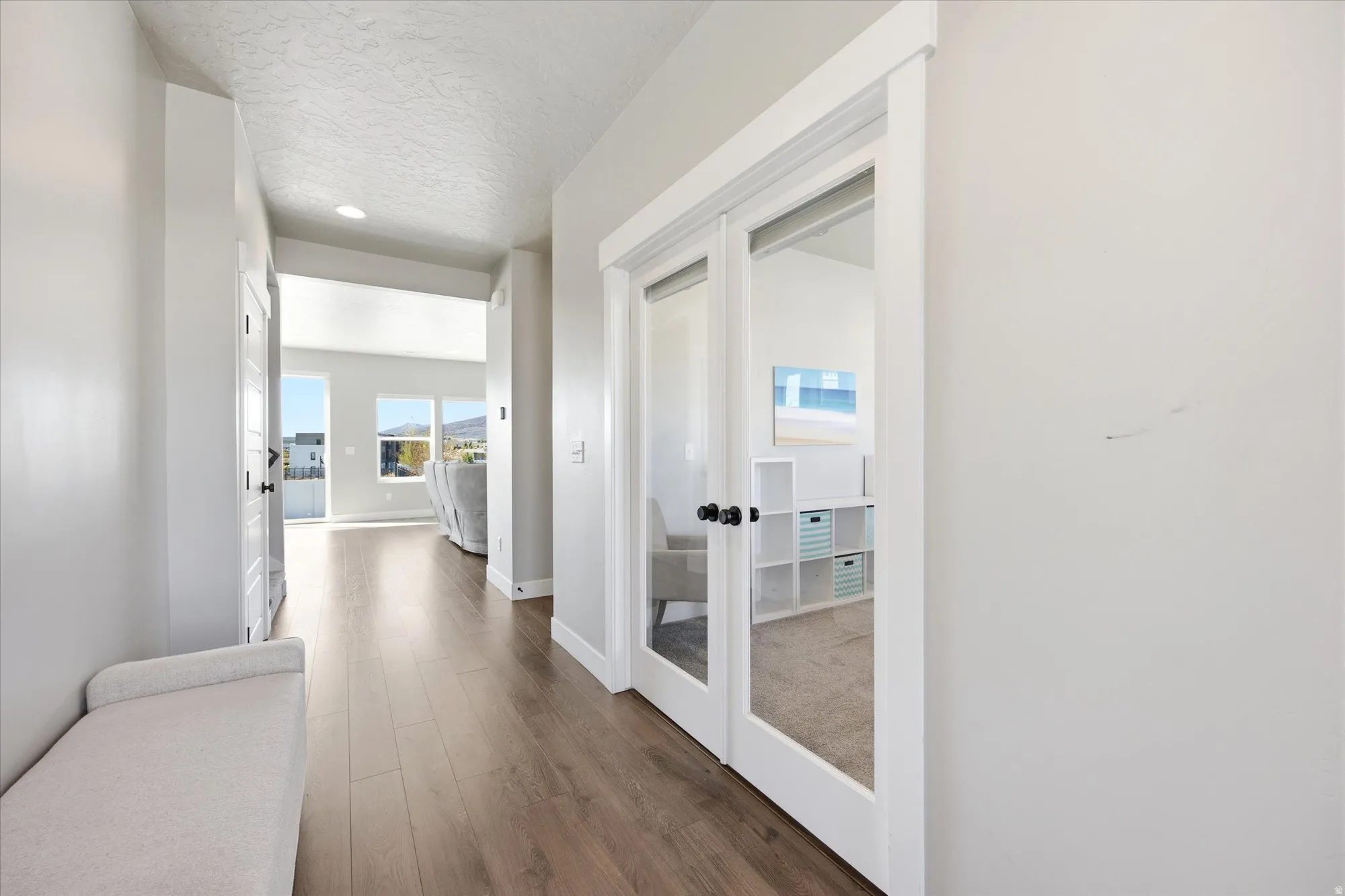 Hallway featuring wood-finish flooring, light-toned walls, and a recessed ceiling light