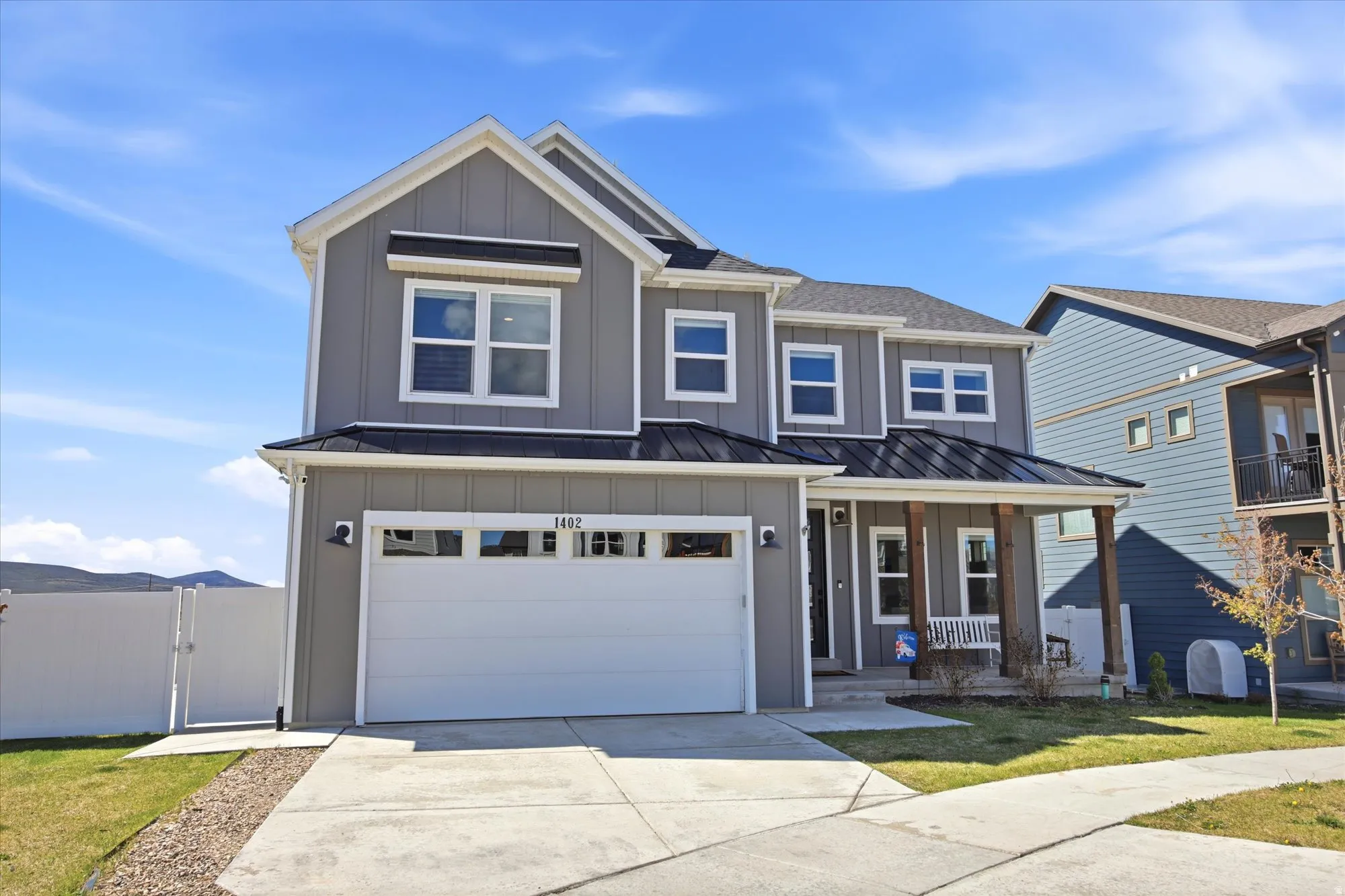 Contemporary two-story residence featuring grey board-and-batten siding and white trim