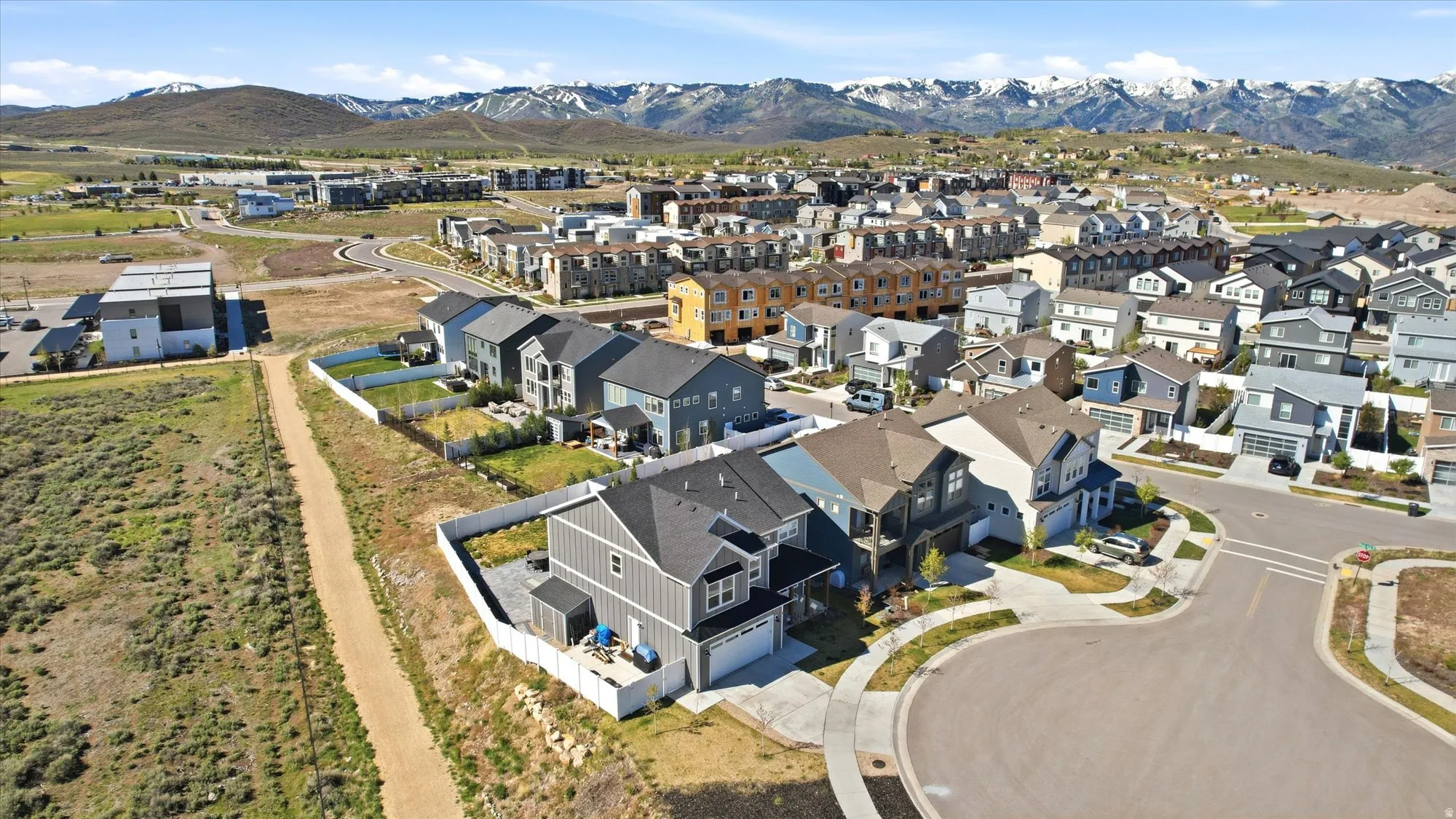 Residential community featuring contemporary architecture, paved streets, and mountainous terrain in the distance