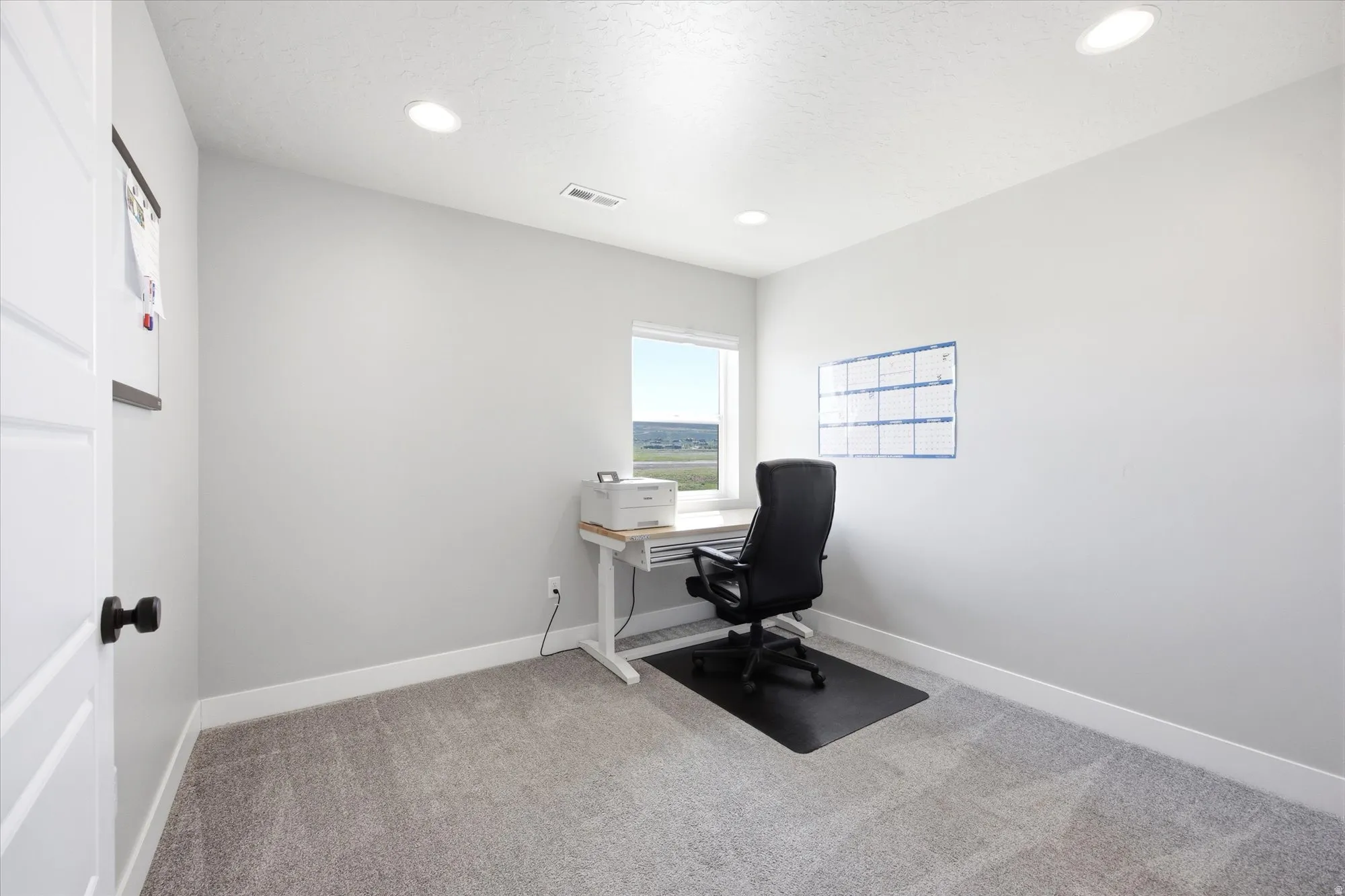 Inviting room with plush carpeting, crisp white trim, and a window providing natural light