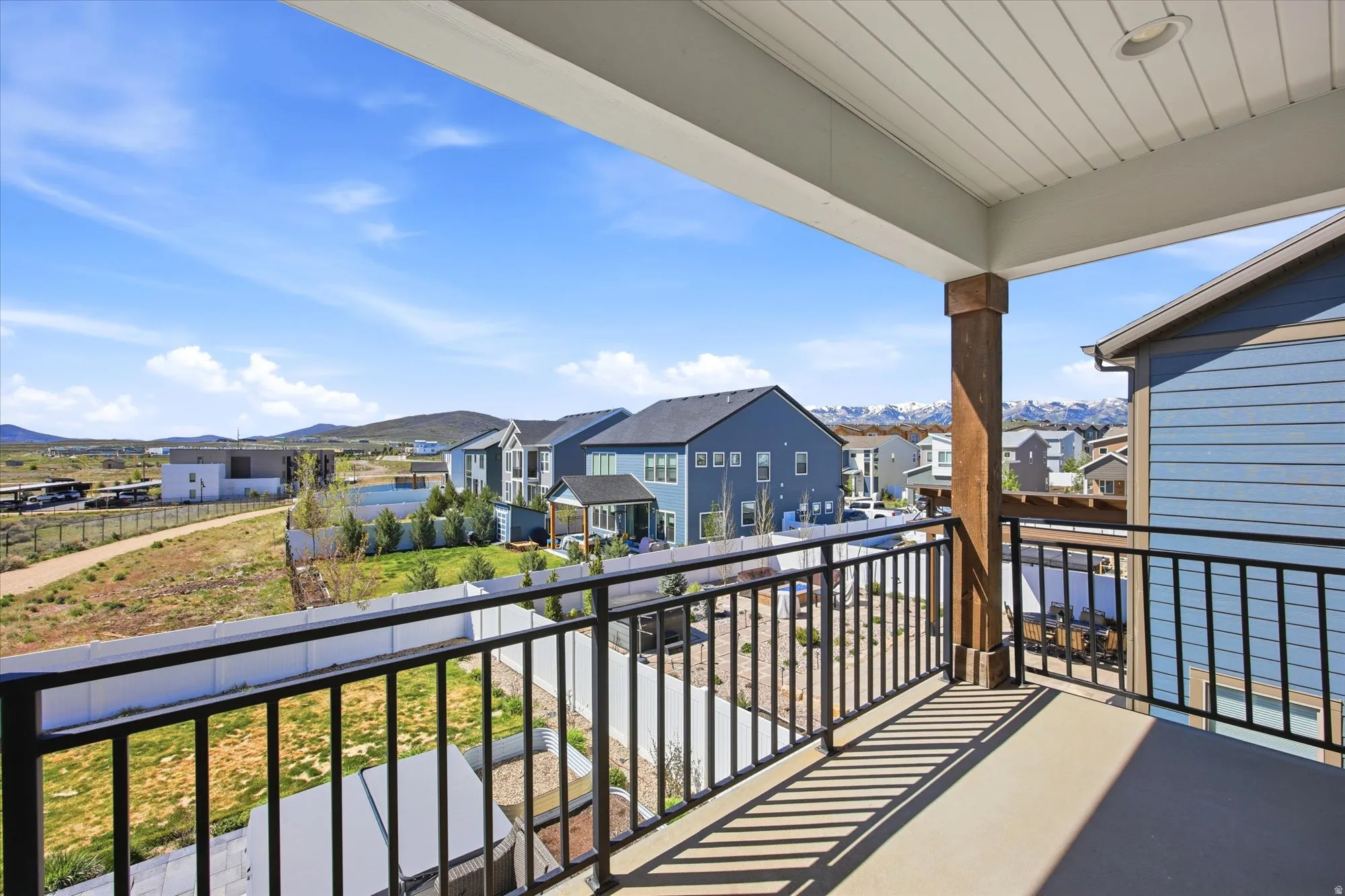 Covered balcony featuring a wood-finish support column and black metal railing
