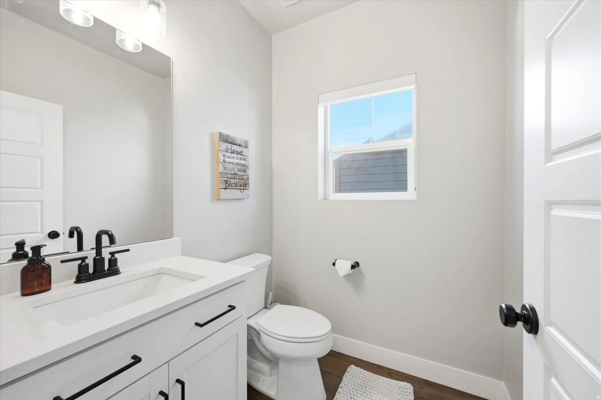 Bathroom featuring a white vanity with an integrated sink, matte black faucet, and coordinating cabinet hardware