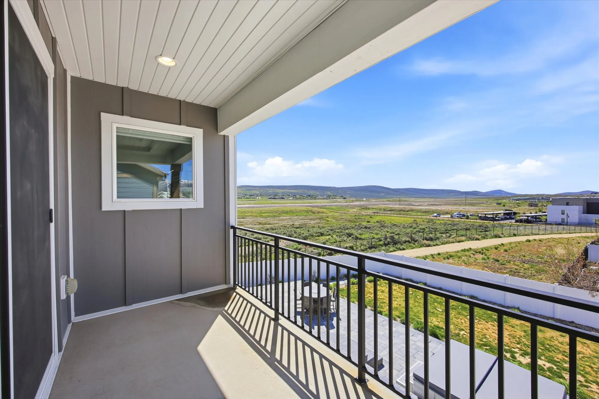 Balcony featuring a black wrought iron railing, concrete flooring, and a recessed ceiling light