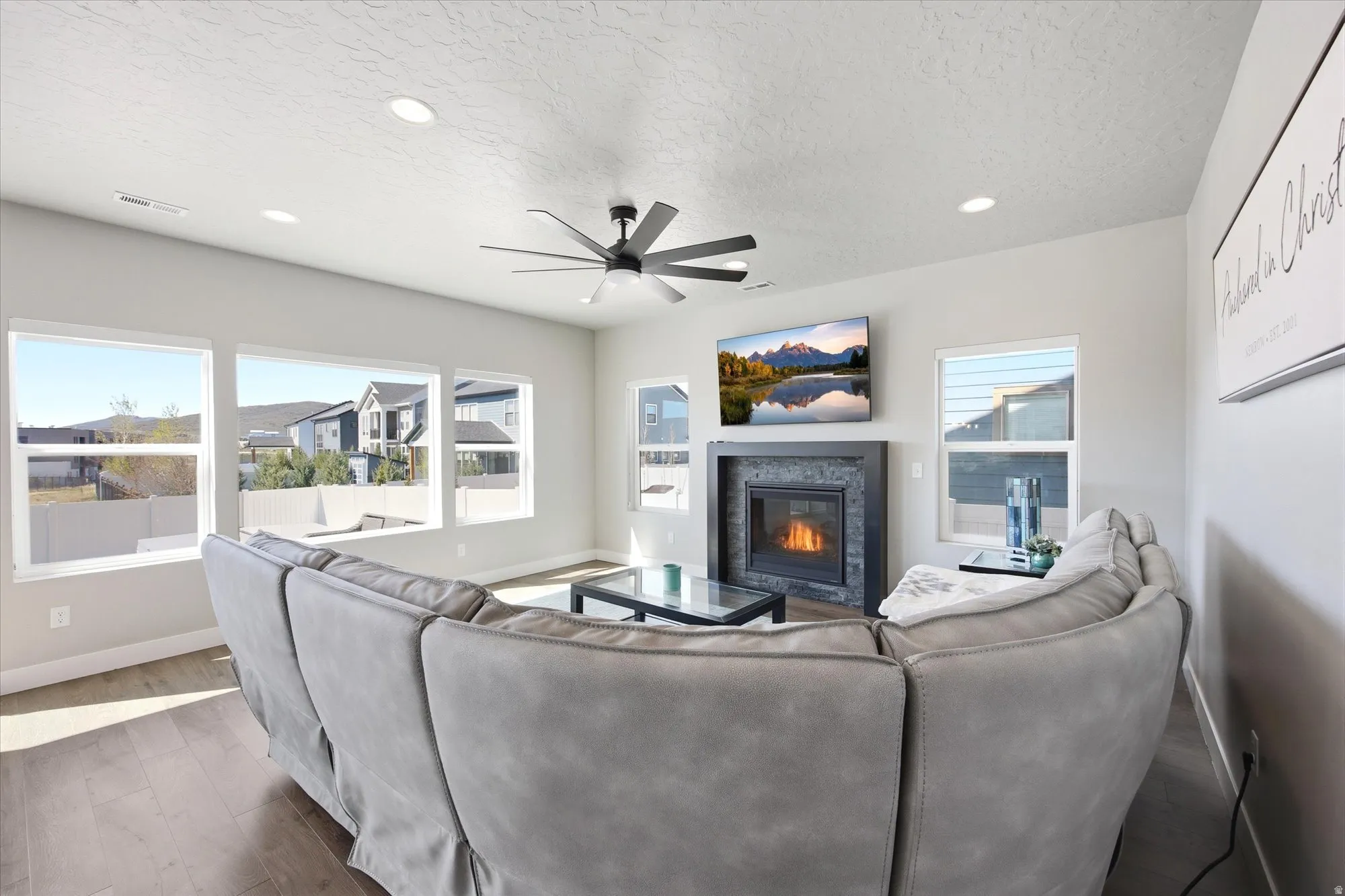 Living space featuring a tiled fireplace with a mantel, recessed lighting, and a ceiling fan