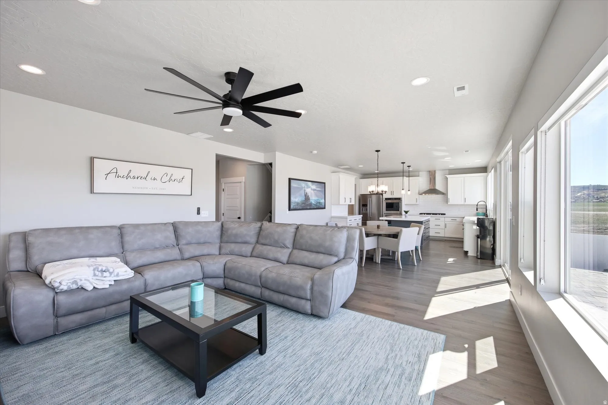 Open-concept living area featuring wood-finish flooring, recessed lighting, and a modern ceiling fan