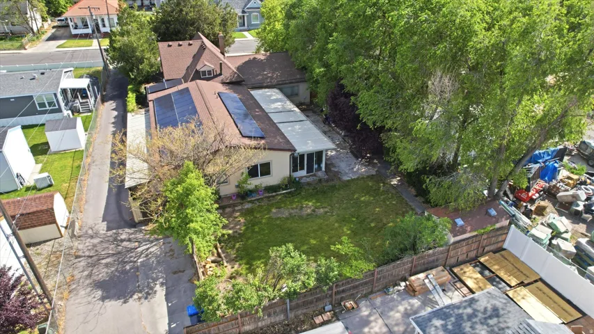 Single-story residence featuring a brown shingle roof with solar panels