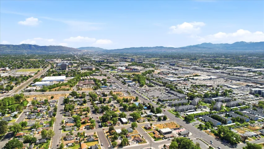 Expansive aerial showcasing a diverse urban and suburban landscape with residential housing, commercial buildings, and major roadways