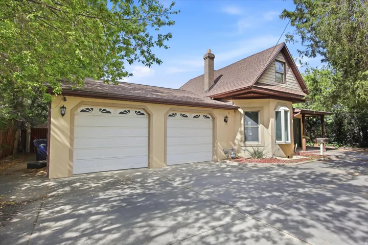 Exterior featuring a two-car garage with decorative window panels, stucco siding, and a prominent bay window