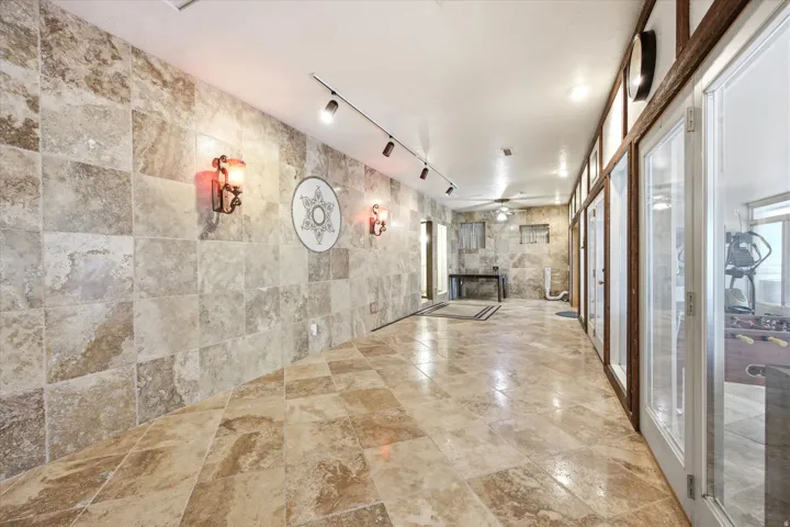 Hallway featuring stone tile flooring and wall accents