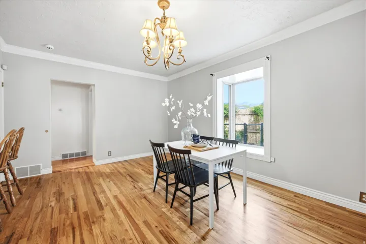 Dining area with wood-finish flooring, light gray walls, and white trim