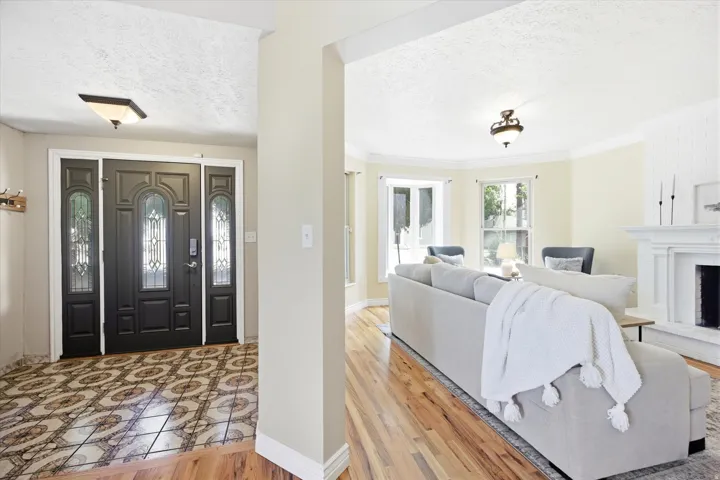 Foyer entrance featuring a dark-paneled door with decorative glass inserts, flanked by matching sidelights