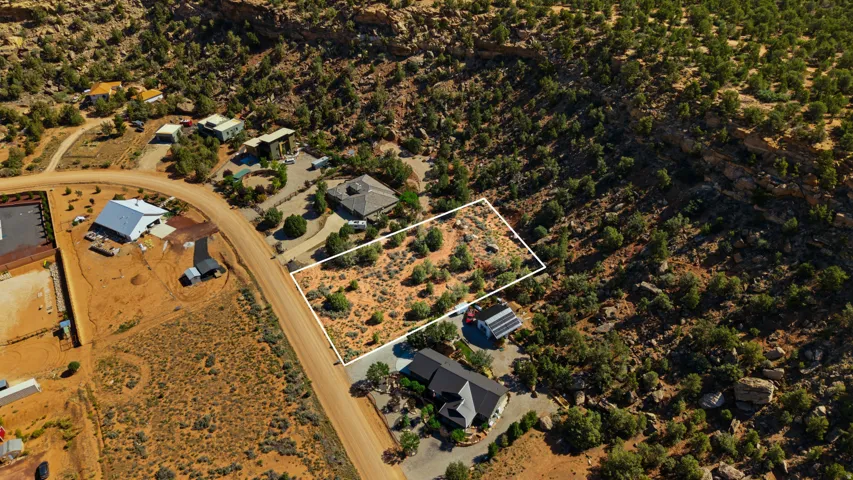 Expansive desert lot featuring a defined perimeter, natural scrub vegetation, and direct road frontage