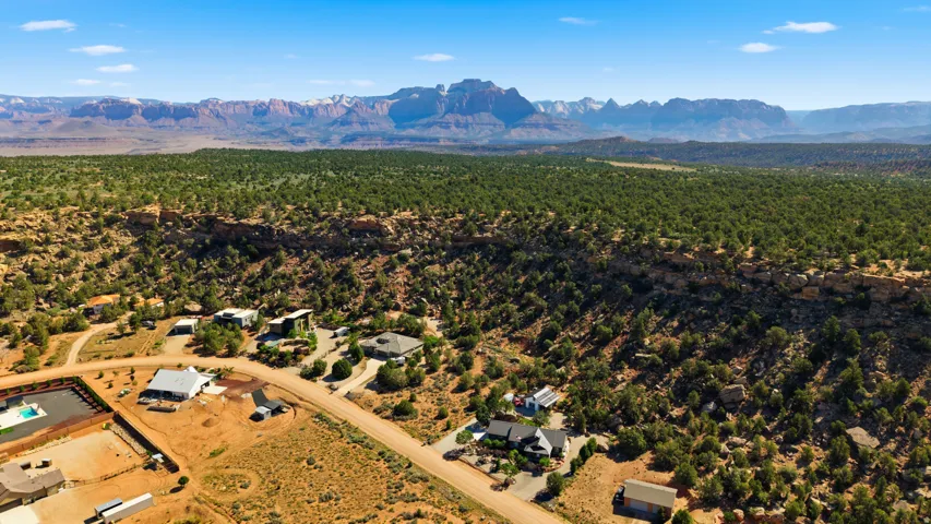 Expansive desert landscape featuring scattered residential properties and a distant mountainous horizon
