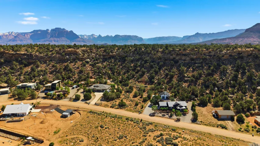 Expansive desert landscape featuring multiple properties, rugged terrain, and distant mountain ranges