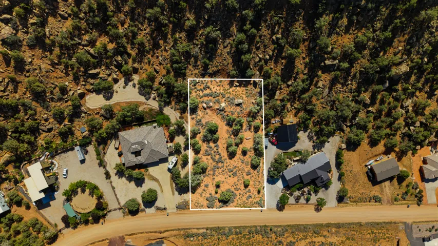 Expansive undeveloped lot featuring natural desert vegetation, rocky terrain, and direct road access