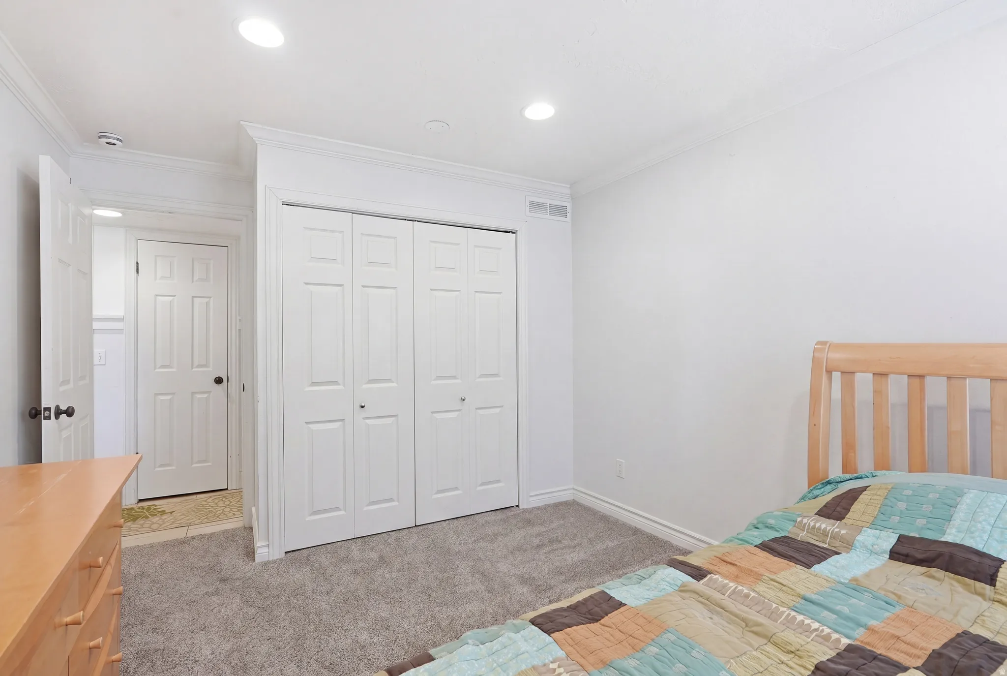 Bedroom featuring a built-in bifold closet, recessed lighting, crown molding, and grey carpet