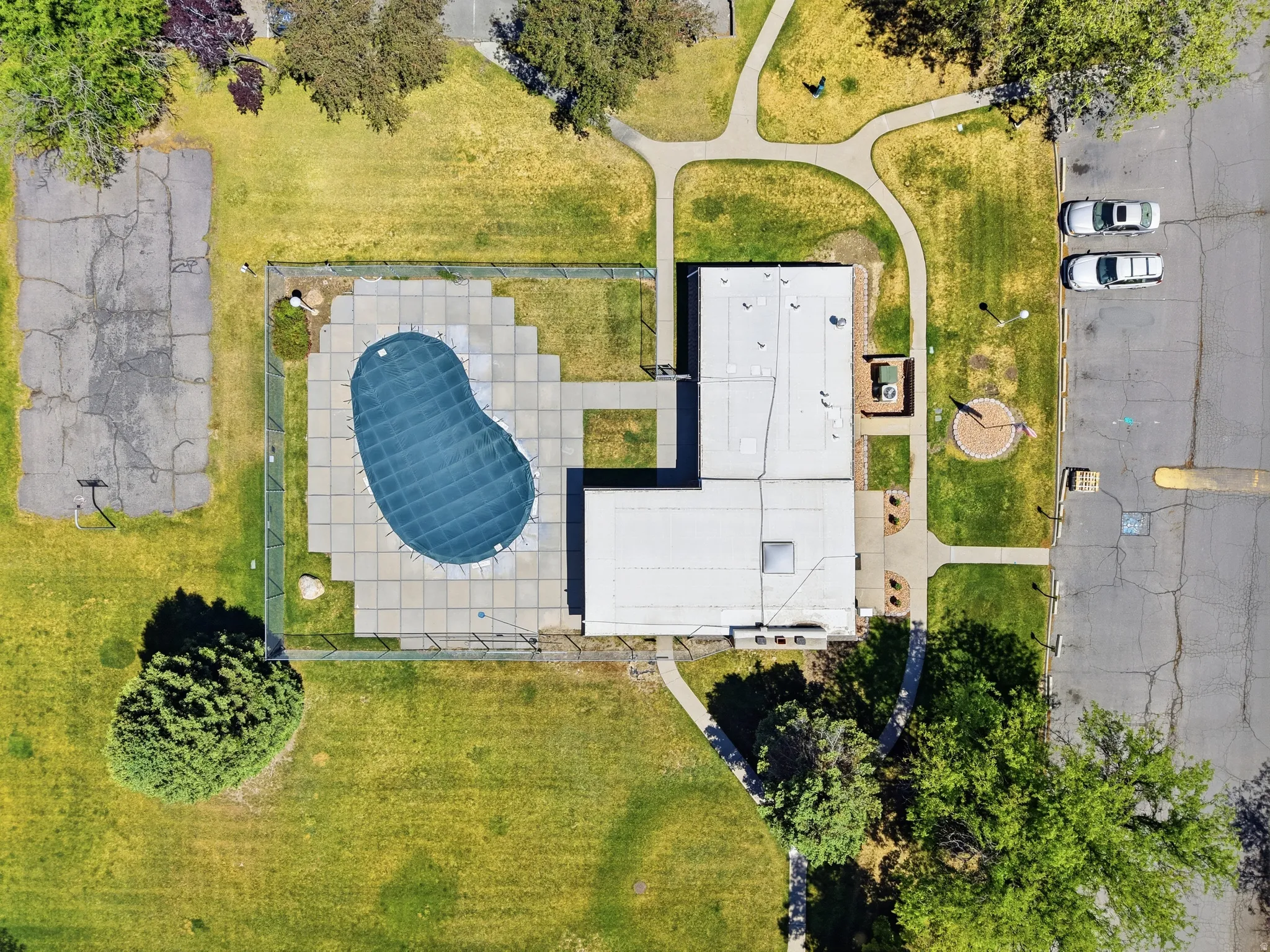 Outdoor pool area featuring a covered pool, surrounding hardscaping, and perimeter fencing
