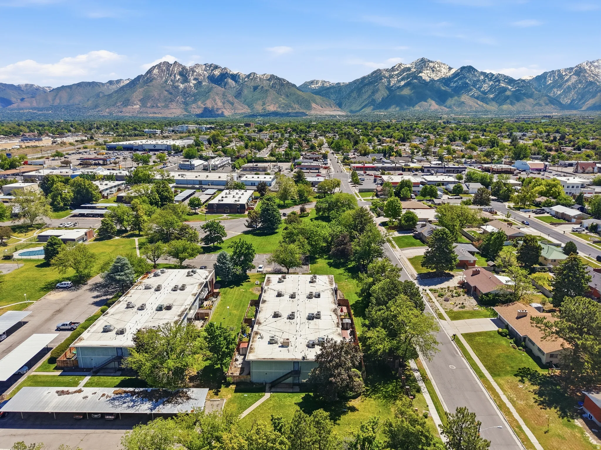 Expansive aerial showcasing a neighborhood with mountainous terrain in the background