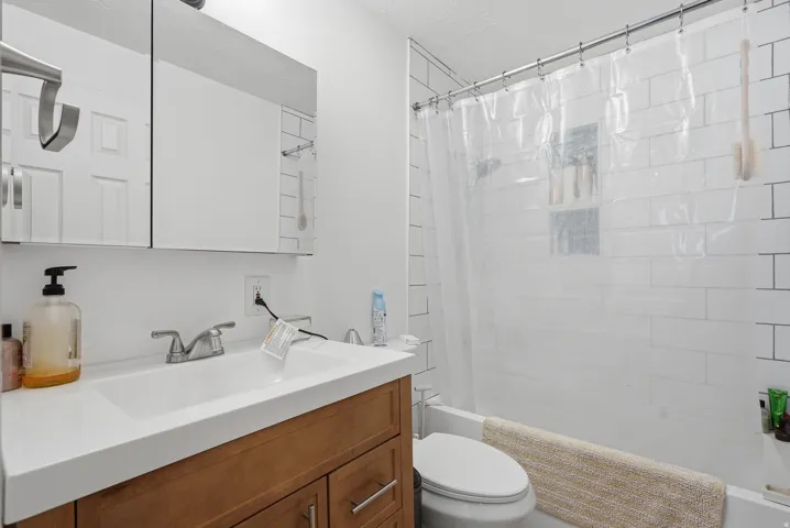 Bathroom featuring a warm wood-finish vanity with an integrated sink and brushed nickel faucet