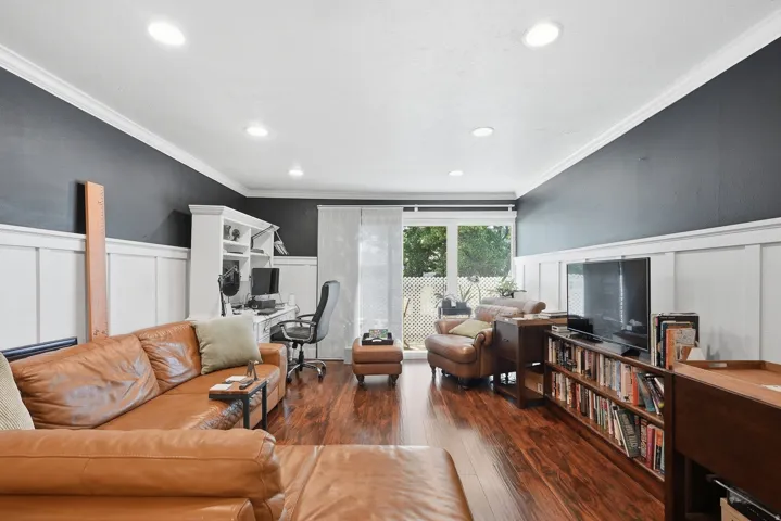 Spacious living area featuring wood-finish flooring, recessed lighting, and crown molding