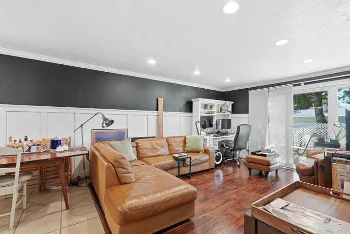 Spacious living area featuring wood-finish flooring, recessed lighting, and board and batten wall detailing