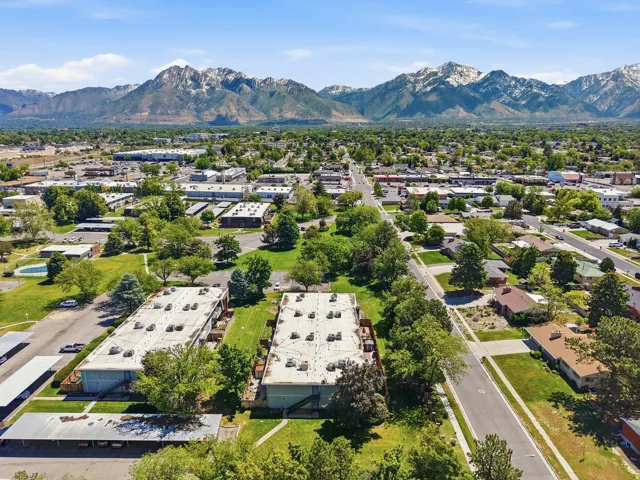 Expansive aerial showcasing a neighborhood with mountainous terrain in the background