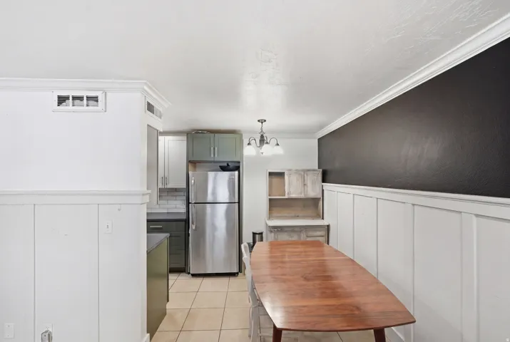 Dining area featuring white board and batten wainscoting with a contrasting dark accent wall