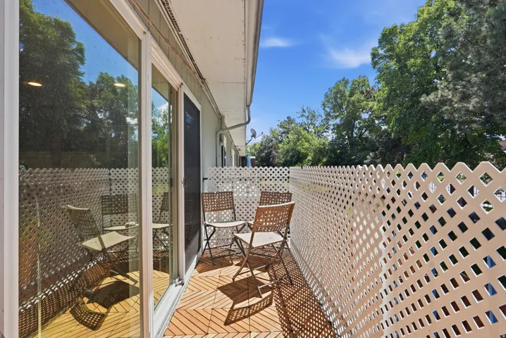 Private outdoor balcony featuring wood-look tile flooring and a lattice privacy screen