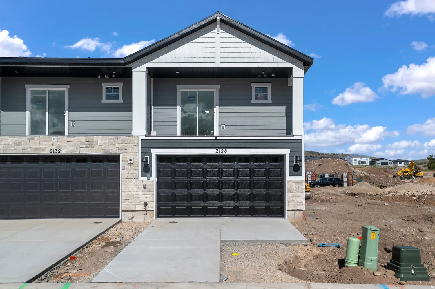 Modern townhome exterior featuring a two-tone facade with stone accents and horizontal siding