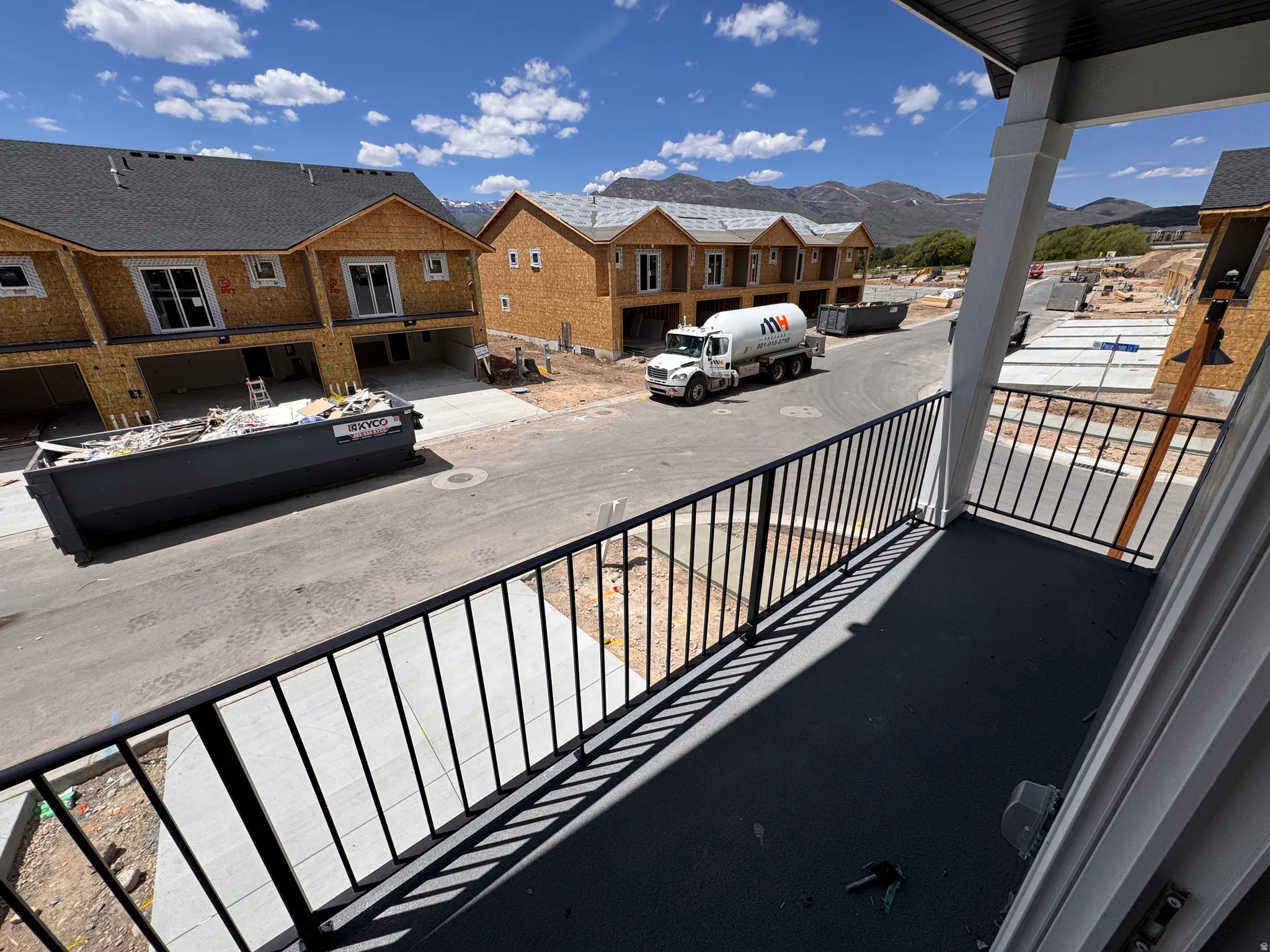 Balcony with black metal railings and painted concrete flooring