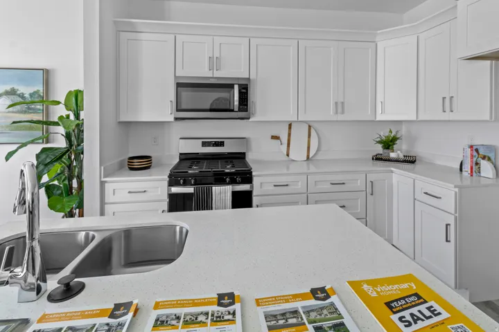 Modern kitchen featuring white shaker cabinetry, stainless steel appliances, and light-toned countertops