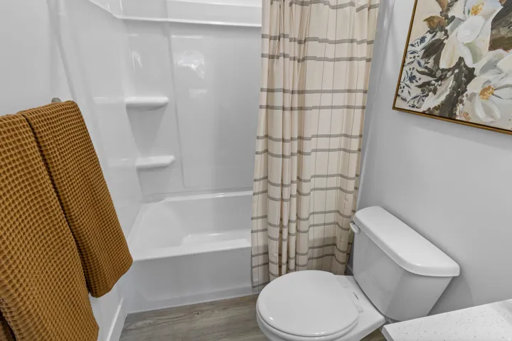 White fiberglass tub and shower combination with integrated shelving