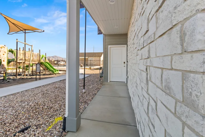 Stone brick exterior with a white entry door and covered front porch