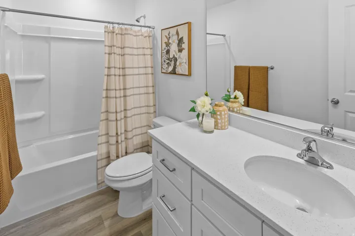 Bathroom featuring a white vanity with an integrated sink, polished chrome faucet, and a large mirror