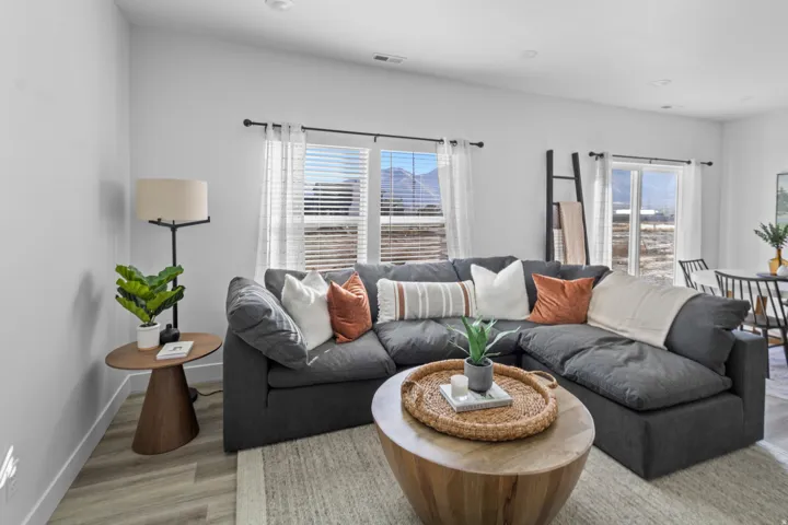 Spacious living area featuring light wood-finish flooring, white walls, and recessed lighting