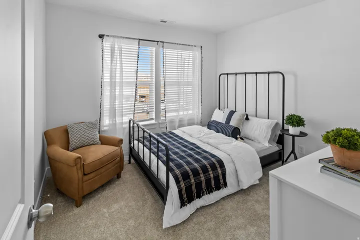 Room featuring light gray carpeting, neutral wall paint, and a window with blinds and sheer curtains