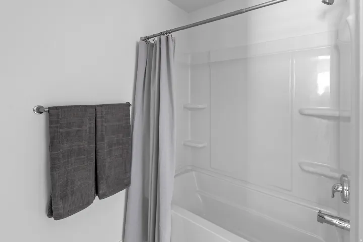 Bright white tub/shower combination with integrated shelving