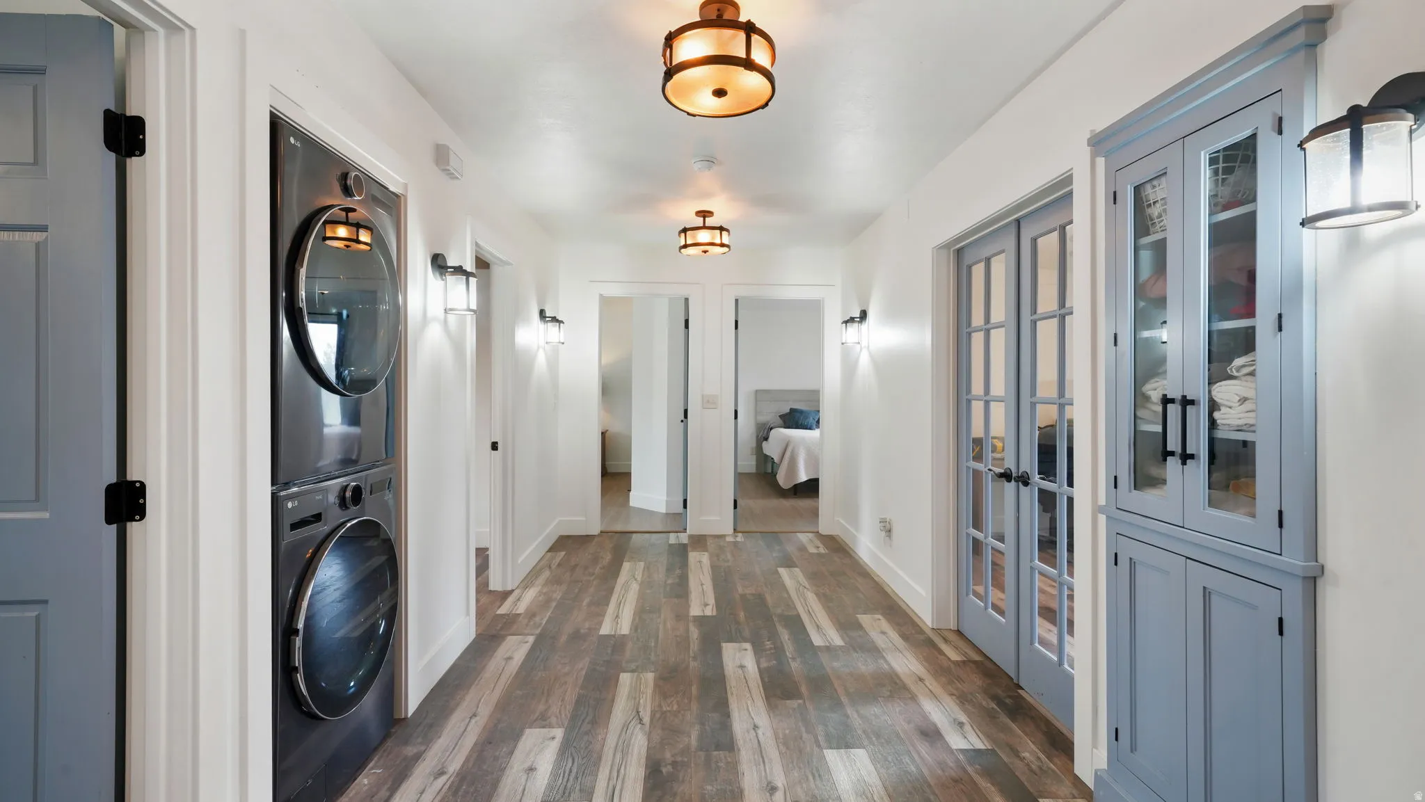 Hallway featuring wood-finish flooring and multiple light fixtures