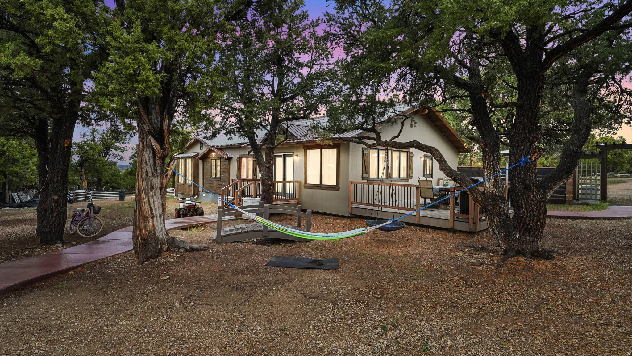 Exterior featuring a metal roof, multiple windows with natural wood trim, and a spacious wooden deck with railings
