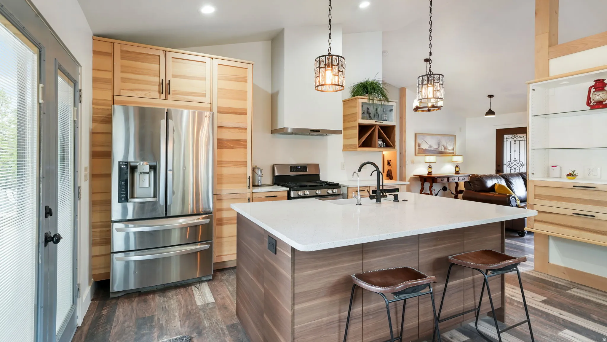 Contemporary kitchen featuring a large center island with seating, stainless steel appliances, and a gas range
