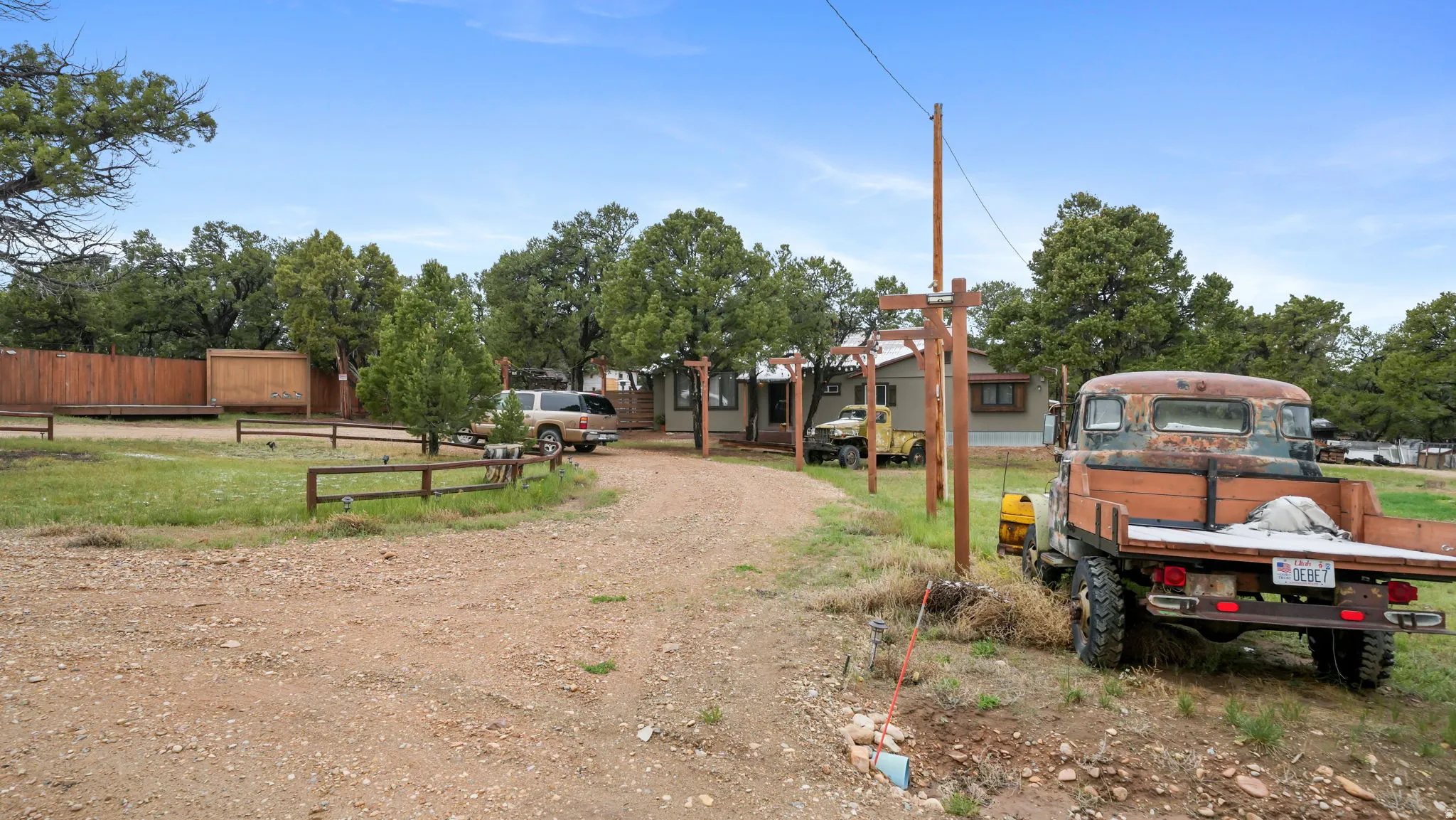 Gravel driveway leading to a single-story residence with a light-colored exterior and a covered entry