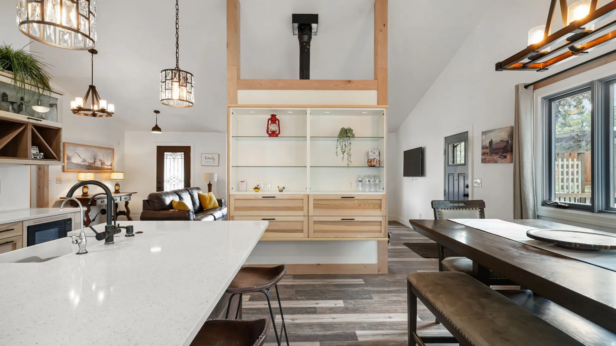 Open concept interior featuring a kitchen island with a built-in sink and light-colored countertop