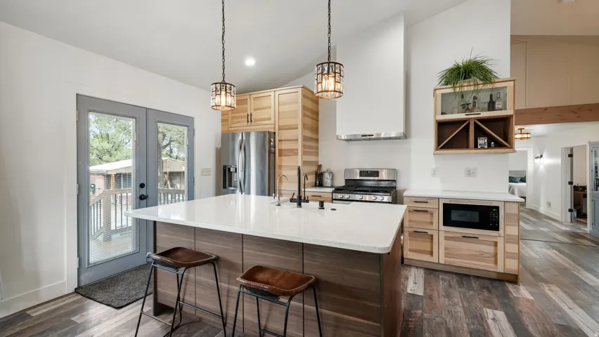 Modern kitchen with a large central island featuring a white countertop and seating