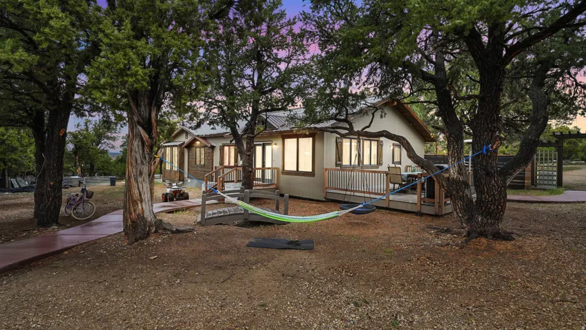 Exterior featuring a metal roof, multiple windows with natural wood trim, and a spacious wooden deck with railings