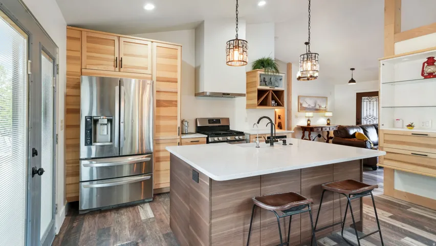 Contemporary kitchen featuring a large center island with seating, stainless steel appliances, and a gas range